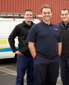 three of our plumbers in Bothell are standing raedy by their truck